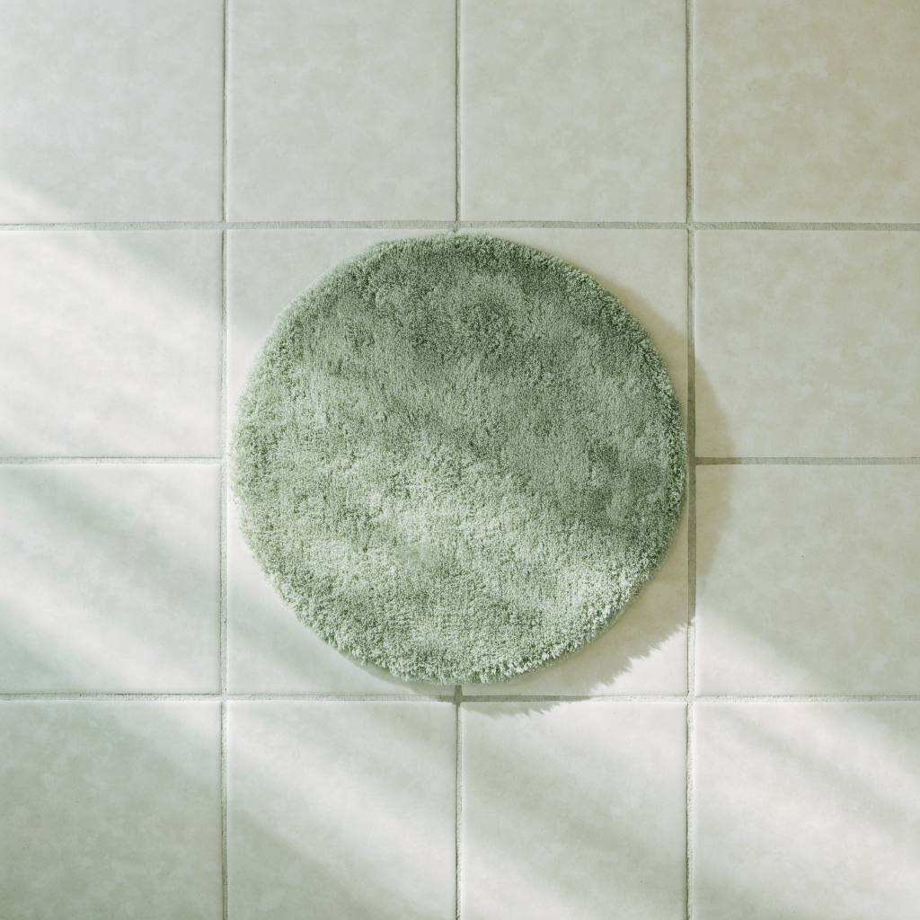 Tapis de bain rond vu de dessus sur un carrelage clair